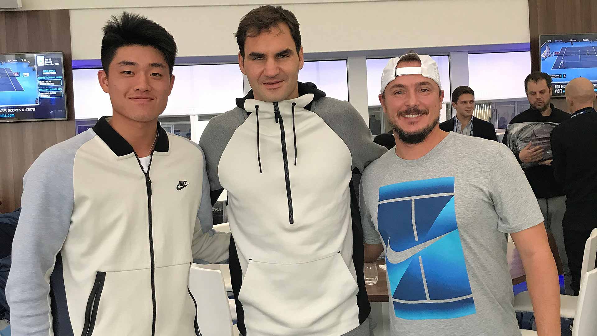 Wu Yibing junto a Roger Federer y su entrenador Nahum García Sánchez.