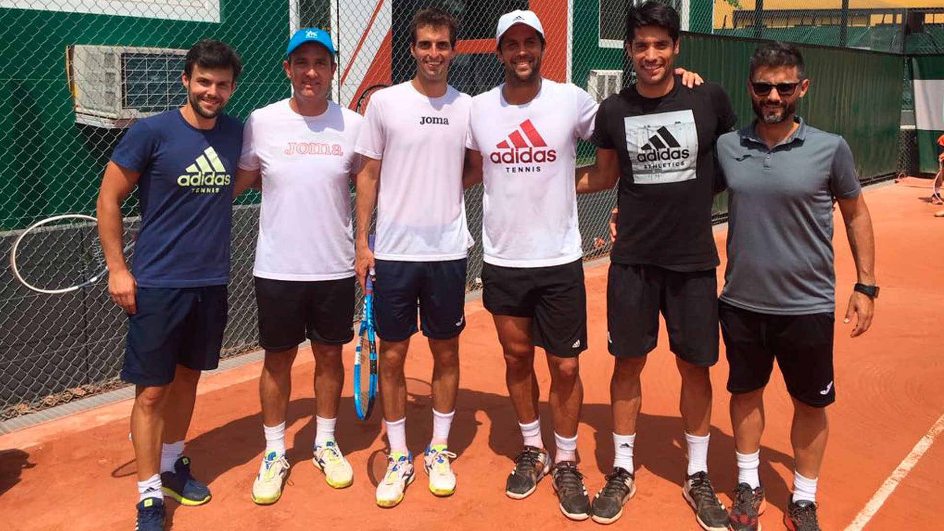 Albert Ramos Vinolas and Fernando Verdasco pose for a photo with members of their teams at Roland Garros.
